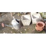 A pair of concrete planters, strawberry pot and vintage watering can
