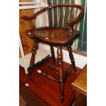 A reproduction stick back bow elbow chair with moulded solid elm seat, set on turned supports