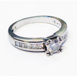 A hallmarked 950 platinum ring, set with central brilliant cut diamond with ten flanking paved