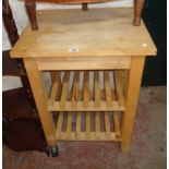 A 23 3/4" modern blonde wood kitchen preparation unit with butcher's block style top and two slatted