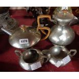A four piece Tudric pewter tea set with hand beaten finish and canework handles