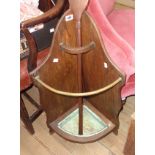 An early 20th Century stained oak corner stick stand with brass rail and drip tray