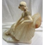 A 1920's carved alabaster statue of a lady sat on a large chair, with painted decoration and