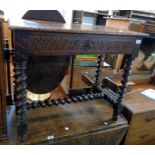 A 33" Victorian carved oak side table with long frieze drawer, set on a heavy barley twist open