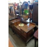 A 3' 8 1/2" Edwardian mahogany and strung well dressing chest with bevelled oval swing mirror, two