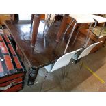 A 5' Edwardian stained oak extending dining table, set on turned and reeded legs with iron castors -