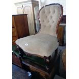 A Victorian walnut part show frame spoon back nursing chair with button velour upholstery, set on