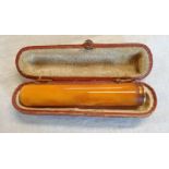 A cased gold mounted and reconstituted amber cigarette holder