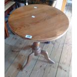 An 18 1/2" diameter waxed pine pedestal table, set on turned pillar and tripod base