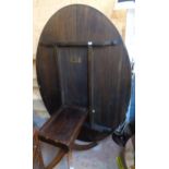 A 6' 5" mahogany and rosewood cross banded oval tilt-top dining table, set on turned pillar and