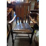 An early 20th Century oak framed high lath back elbow chair with rexine upholstered drop in seat -