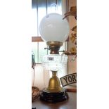 A table oil lamp with cut glass reservoir, milk glass shade, chimney, and ceramic base