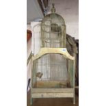 An old large wood and wirework bird cage with domed top and painted gold finish