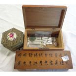A wooden pen box with Chinese calligraphy to lid, a wooden moneybox with few coins, and a Japanese