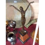 An Art Deco style bronzed figurine of a lady with her arm in the air, on a stone plinth