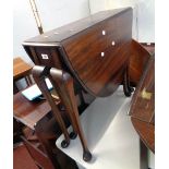 A 29 1/2" early 20th Century stained walnut Sutherland table, set on cabriole legs with pad feet