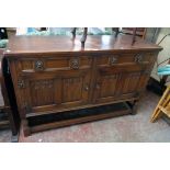 A 4' 7 1/2" 20th Century polished oak sideboard with two frieze drawers and quadruple linen-fold