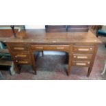 A 5' mid 20th Century oak kneehole desk with central frieze drawer, flanking slides and six short