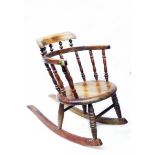 A 19th Century stained beech child's bow spindle back rocking chair with circular seat panel and