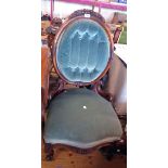A Victorian carved part show frame drawing room chair with button back upholstery, set on ornate