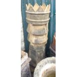 An old tall chimney pot with crowned top