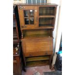 A 31" early 20th Century oak bureau bookcase with Arts & Crafts style decoration to cupboard door