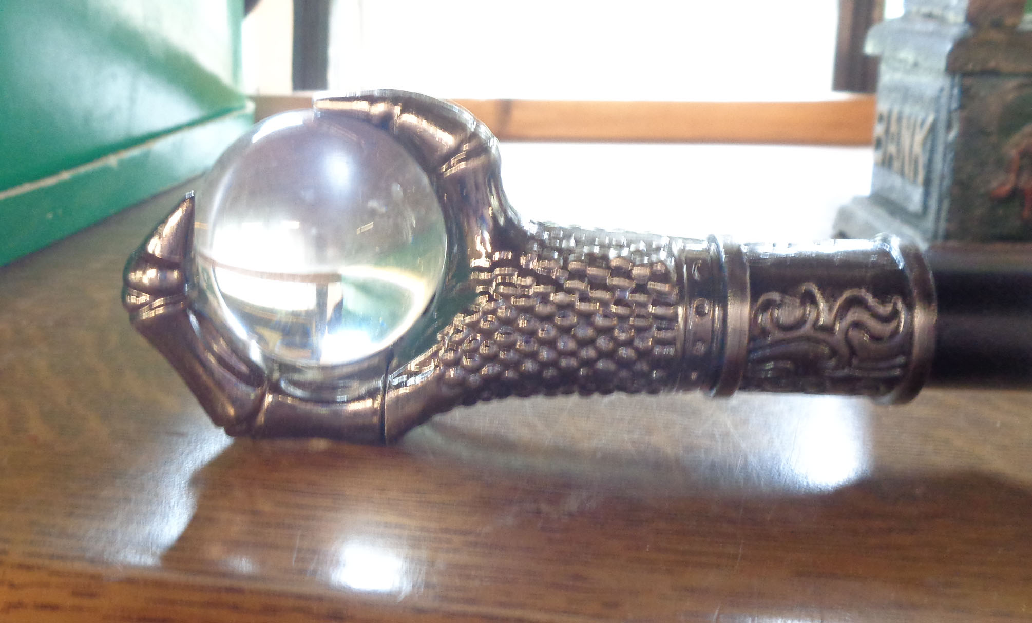 A modern reproduction walking stick with glass ball and metal claw top