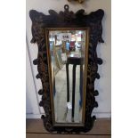 A small antique fret-cut narrow oblong wall mirror with remains of painted and lacquered trailing