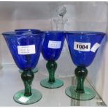 A decanter with associated stopper and a set of four modern blue soda glasses