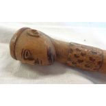 A carved wood walking stick with head pattern knop