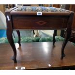 An Edwardian walnut and strung locker piano stool with remains of tapestry to seat, set on