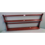 A 3' 2" Ercol dark elm wall mounted two shelf plate rack with shaped sides and original label