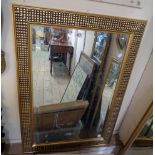 A modern gilt framed bevelled oblong wall mirror with decorative textured border - 3' X 26"