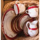 A basket containing a Victorian bone china part tea set