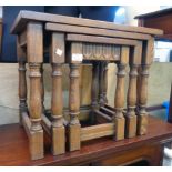 A 20th Century nest of three oak tables with stretcher bases