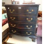 A 25" 20th Century reproduction mahogany serpentine front chest of four long drawers, set on bracket