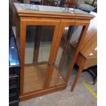 A 32 1/2" modern mixed wood display cabinet with bevelled glazed door panels to front and