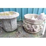 A large concrete garden urn, decorated with putti and swags, another similar and a smaller planter