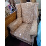 A late Victorian Georgian style wing back armchair upholstered in floral scroll tapestry (some