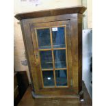 A 22" antique mahogany and mixed wood wall hanging corner cabinet with beaded glazed panel door
