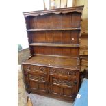A 4' 20th Century polished oak two part dresser in the antique style with two shelf open plate