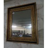 A gilt framed oblong wall mirror with floral scroll moulding