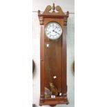 A modern stained wood cased regulator style wall clock with large visible pendulum, two pulleys