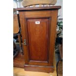 A 15" late Victorian walnut pot cupboard enclosed by a panelled door, set on plinth base - top