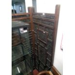 An old carved Eastern hardwood four fold screen decorated with inset fretwork foliate scroll panels,