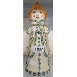 A vintage Jersey pottery stylized figure of a girl in a long coat