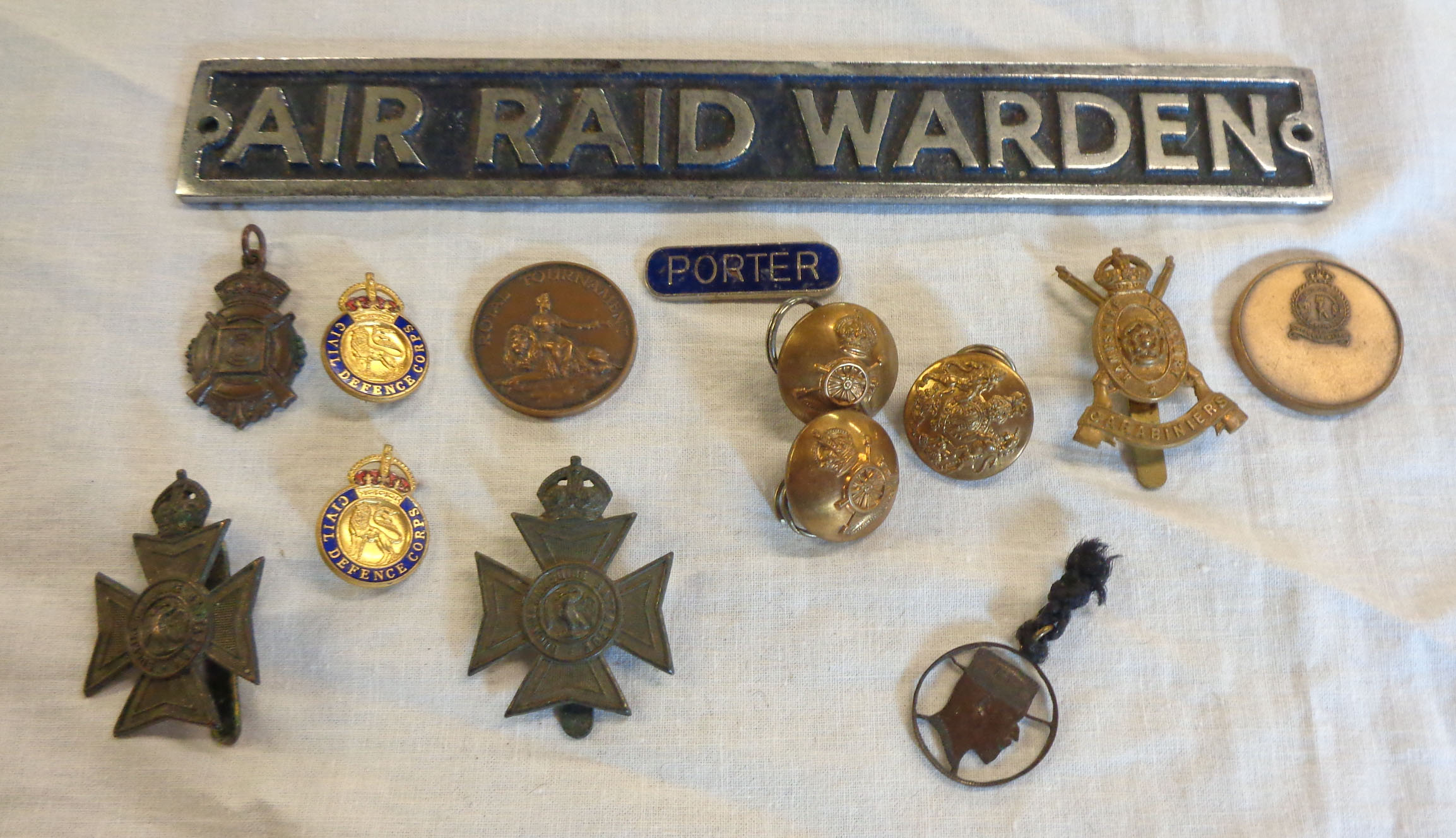 A bag containing various military, Civil Defense and ARP items including Air Raid Warden door