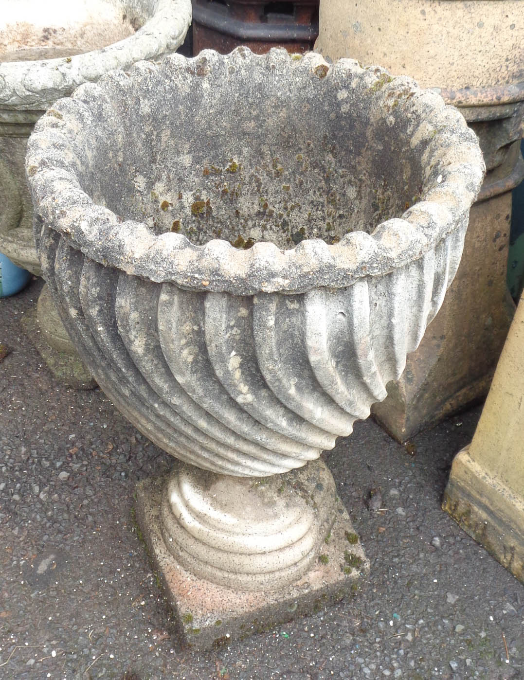 A concrete garden urn with wrythen decoration