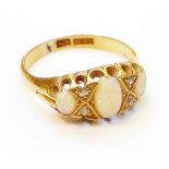 A marked 18ct. yellow metal ring, set with three opals interspersed with tiny old cut diamonds