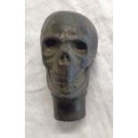 A brass walking stick finial in the form of a human skull